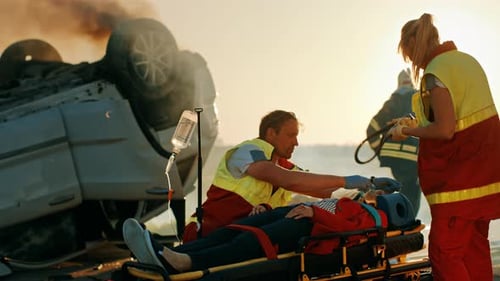 Na cena do acidente de trânsito: paramédicos salvando a vida de uma vítima feminina que está deitada