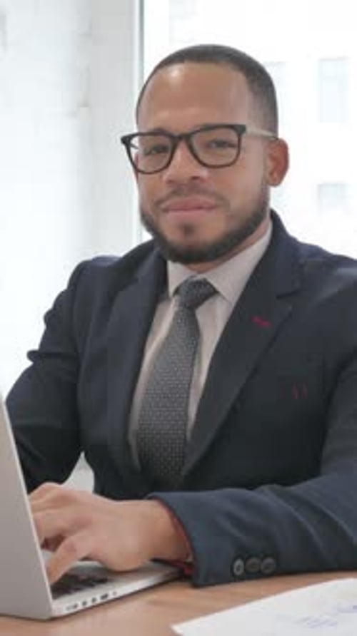 Enthusiastic Businessman Gives Thumbs Up Working at Desk