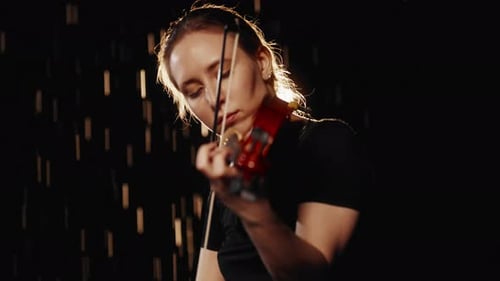 Woman Plays Violin in Dark Room