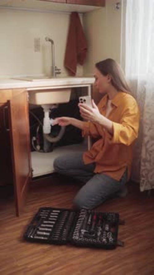 Woman Calling Plumbing Service for Sink Drain Repair
