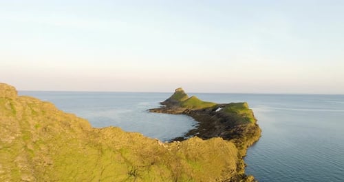 Île côtière au lever du soleil avec des moutons sauvages et des campeurs