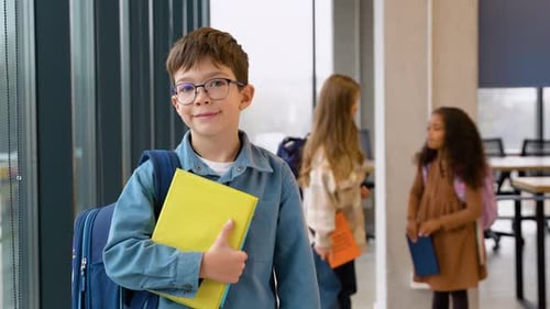 Elementary School Boy with Books in Hallway