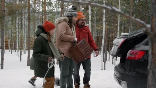 Family Carrying Luggage towards Car while Departing after Winter Vacation