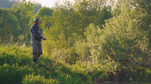Fly fishing. Man fly fishing on the wild river with lots of insects flying in the air