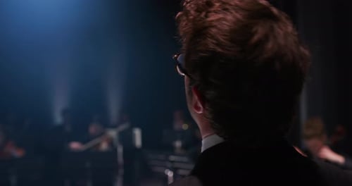 Back View Cinematic Close Up of Conductor Directing Symphony Orchestra with Per