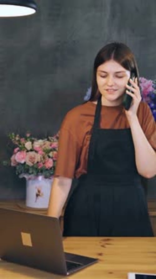 Young Woman Florist in a Flower Shop Orders Flowers From the Greenhouse to Be Delivered Fresh to the