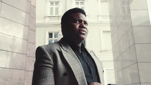 Man in Blazer Using Phone on City Street