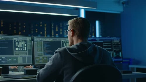 Young Man Coding in a Dark Server Room