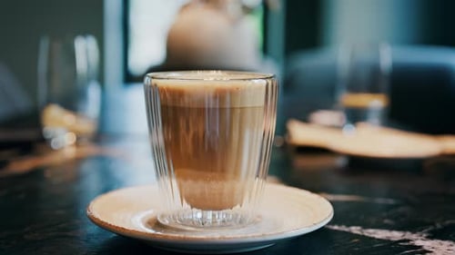 Close up of a glass cup with a latte at a cafe