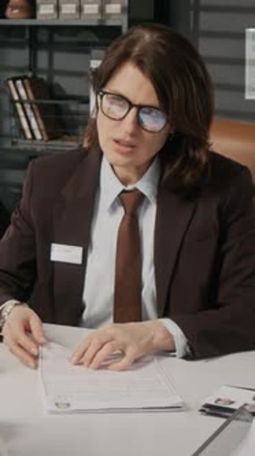 Vertical of Caucasian Female Embassy Official Questioning Visa Applicant