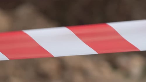 Fita de advertência vermelha e branca balançando no sinal de proteção contra o vento Não cruze a linha vermelha e branca