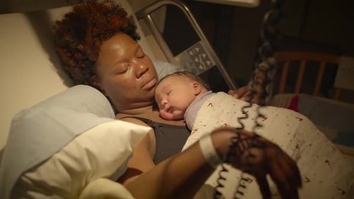 A Mother Holding Her Newborn Baby in a Hospital Bed Capturing a Beautiful Bonding Moment