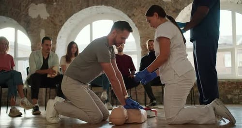Adults Practicing CPR on a Mannequin in Class