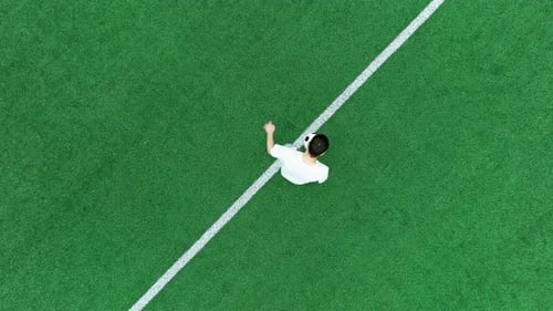 Kicker Makes Dribbles on the Soccer Field Overhead View