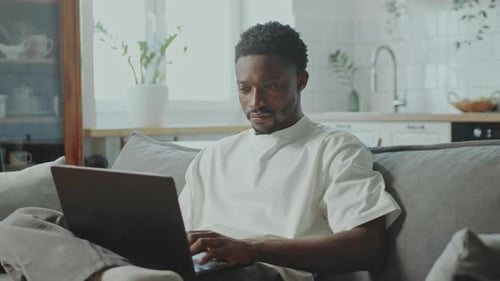 Young Adult Working on Laptop at Home