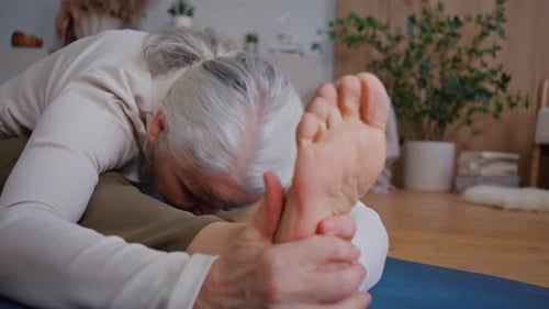Senior Woman Stretching During Yoga at Home