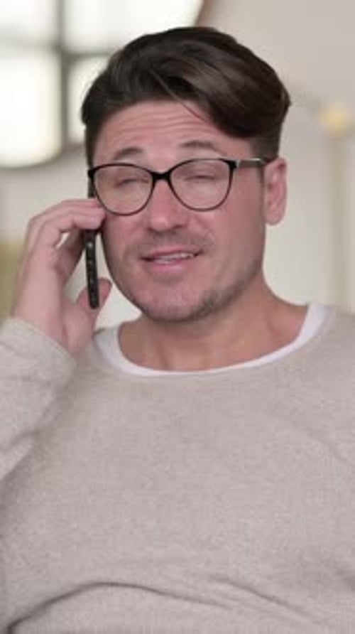 Man with Glasses Talking on Mobile Phone Indoors