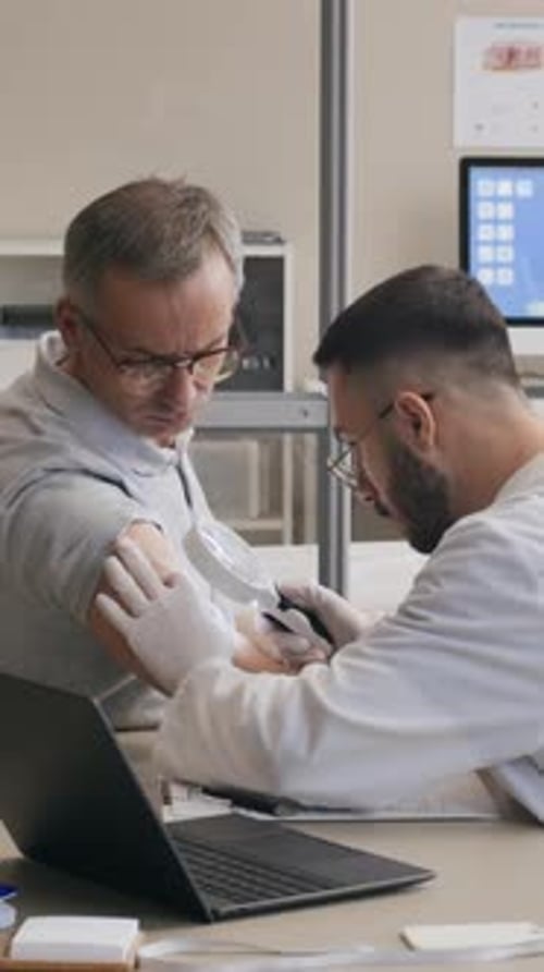 Vertical of Doctor Examining Forearm of Patient during Dermatology Consultation