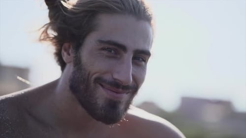 Spanish Bearded Handsome Guy Smiles on the Beach on a Sunny Day
