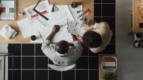 Architects Reviewing Blueprints in a Bright Office