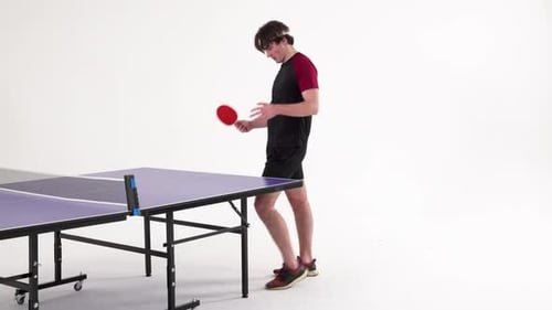 Playing table tennis, young man holding paddle and preparing to serve