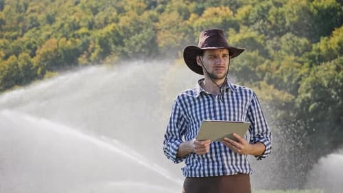 Farmer Using Digital Tablet During Monitoring His Plantation