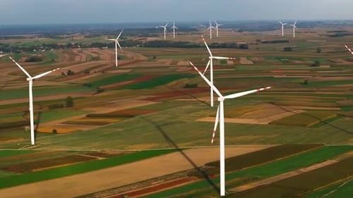 Aerial view of wind turbines in agricultural fields producing renewable energy