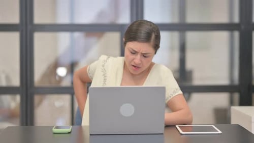 Woman Frustrated Working on Laptop in Office