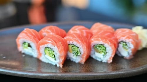 Philadelphia sushi rolls on a black plate at a restaurant
