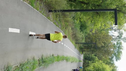 Vertical Screen People Jogging on Road Between Trees