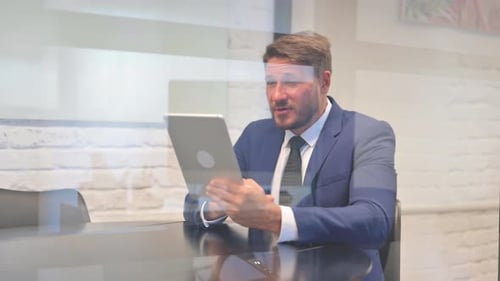 Man Talking on Tablet Device in Bright Office