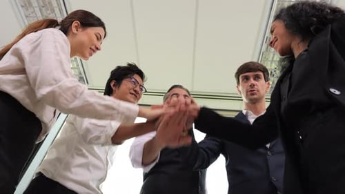 Diverse Business Team Stacking Hands in Office