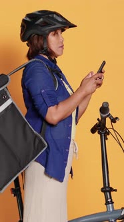 Woman with bike looking at mobile phone