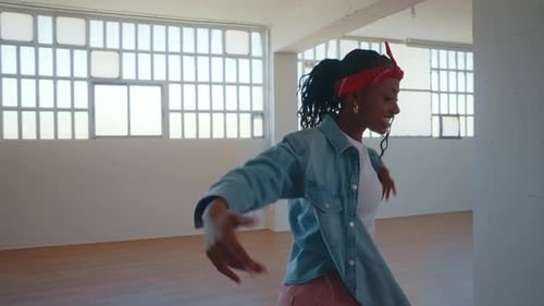 Stylish Woman Dancing Vigorously in an Urban Loft