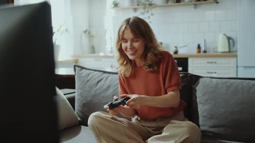 Woman Playing Video Game on Couch at Home