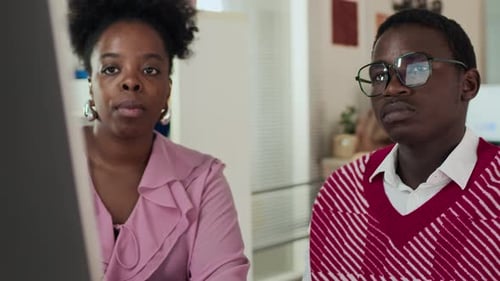 Two African American Colleagues Having Engaged Discussion in Modern Office