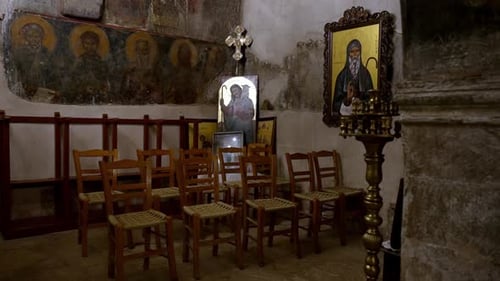interior of old small church with wall hagiographies and saint images, cinematic moody shot