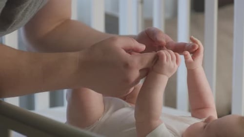 Loving Parent Connects with Baby in Crib