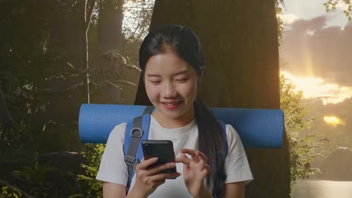 Close Up Of Asian Female Hiker Enjoy Using Smartphone While Exploring Nature