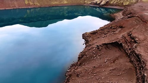 Blue sky reflecting in the water of the lake filling the crater of a sleeping volcano.