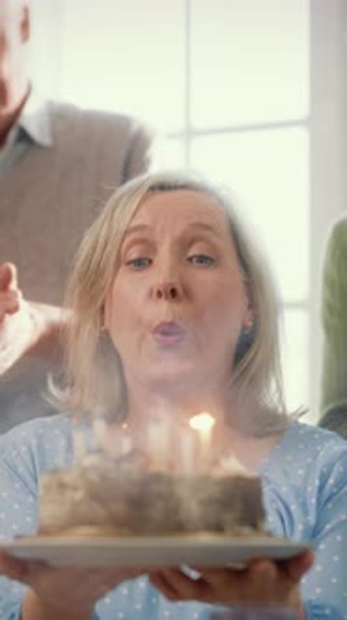 Woman Celebrates Birthday with Cake and Family