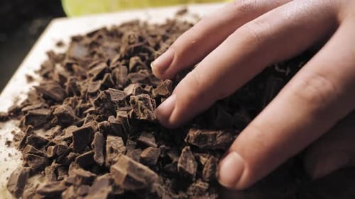 Hands Adding Chopped Chocolate to Baking Mixture