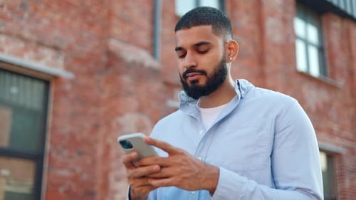 Young Adult Using Phone Outside City Building