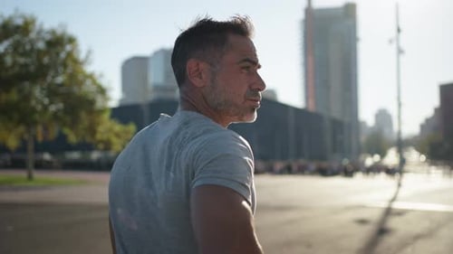 Rear View of Strong Handsome Mature Grey Male Athlete Running on Sunny Day Outdoors