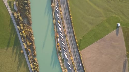 Top Down Aerial View of Highway Interstate Road with Fast Moving Traffic and Parking Lot with Parked