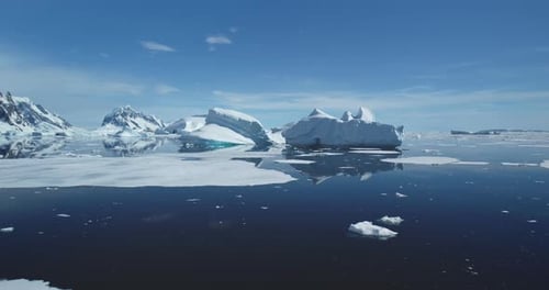 Icebergs From Melting Glacier Float in Icy Ocean