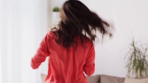 Enthusiastic woman dancing with a hairbrush indoors