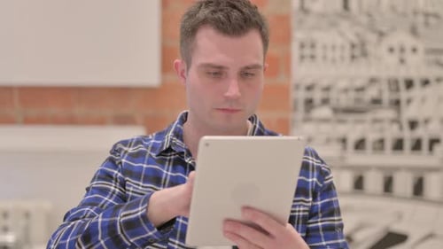 Young Adult Using Tablet Device Indoors