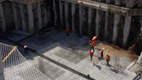 Timelapse of builders at a construction site knitting reinforcement