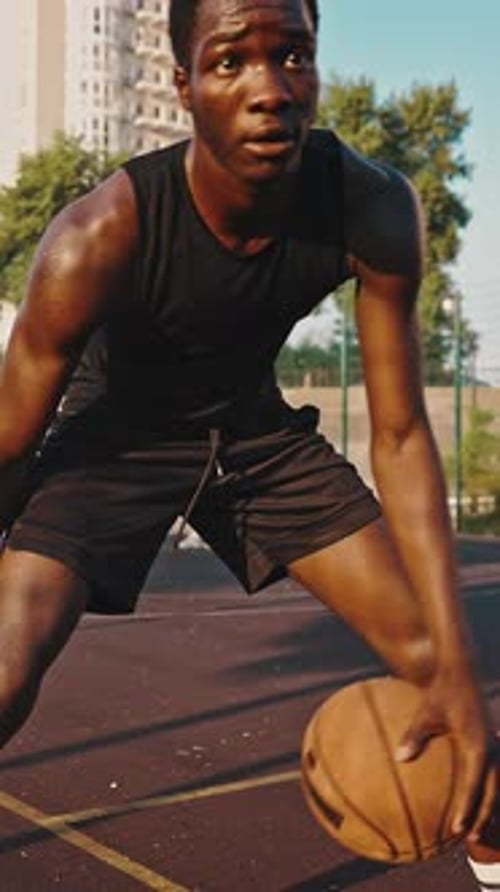 Junger schwarzer Basketballspieler dribbelt den Ball über das Feld Männlicher Athlet trainiert auf dem